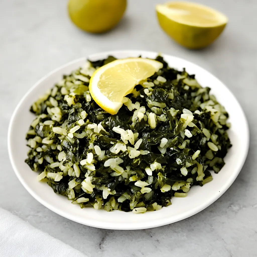 A white plate with a bowl of greens and lemon wedges.