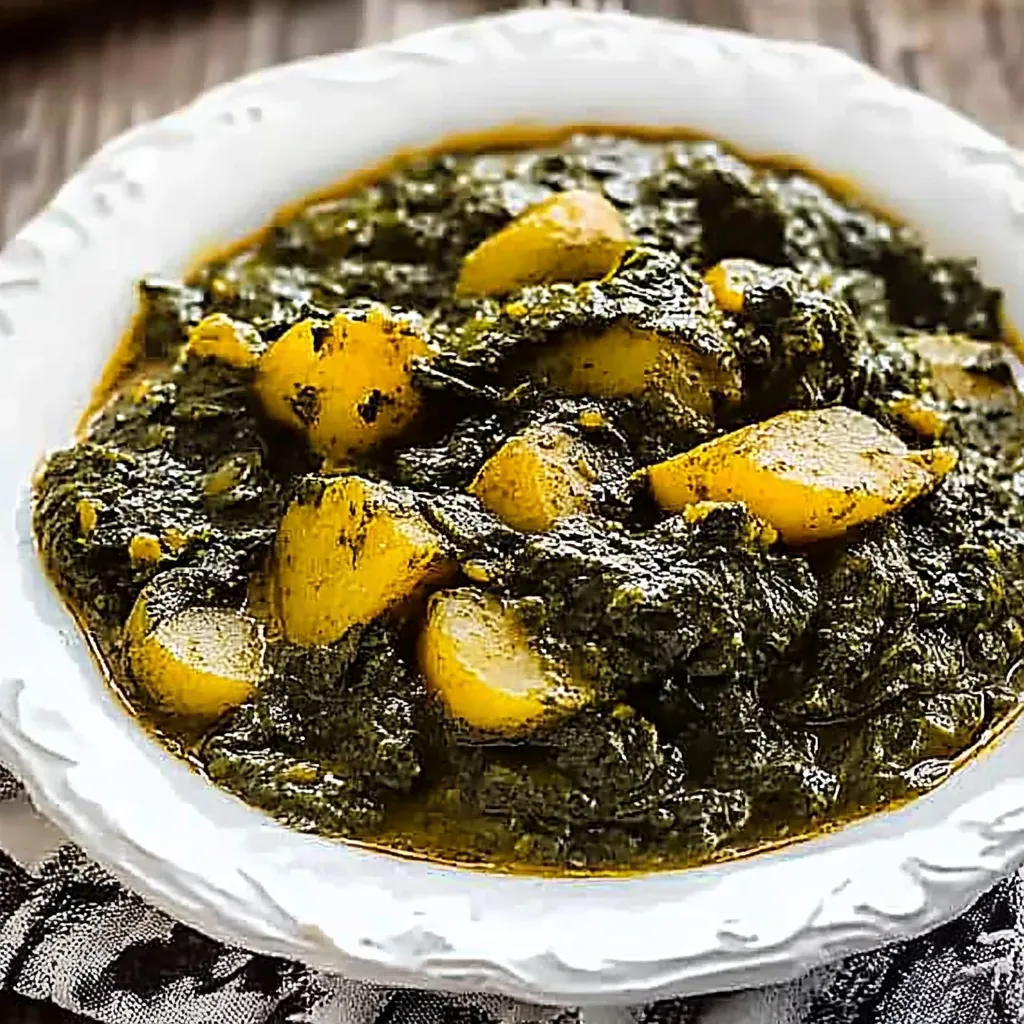 A white bowl filled with a green soup.