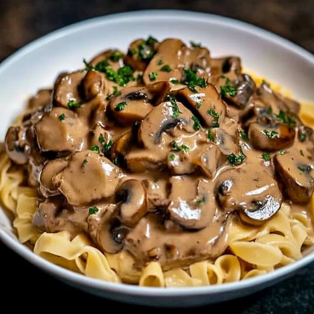A bowl of mushrooms and noodles.