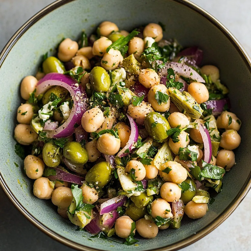 A bowl of food with chickpeas, onions, and other vegetables.