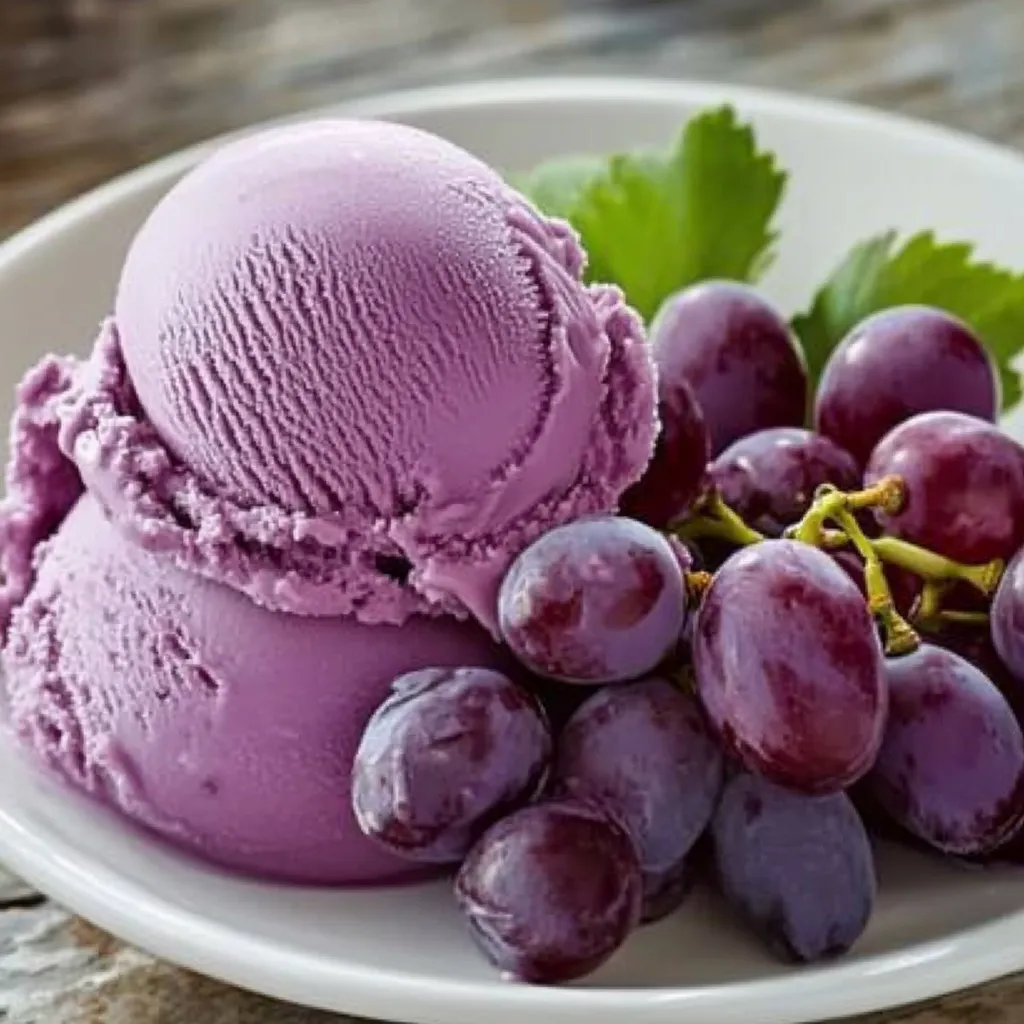 A bowl of grapes and a scoop of purple ice cream.