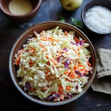 A bowl of coleslaw is placed on a table.