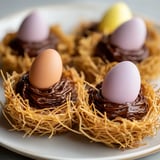 A plate of chocolate desserts with eggs on top.