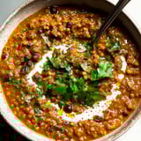 A bowl of soup with a spoon in it.